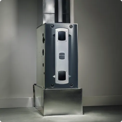 A modern, metallic furnace stands in a dimly lit room.